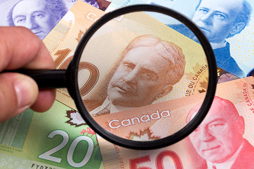 canadian-dollars-in-a-magnifying-glass Express Entry Immigration Canada